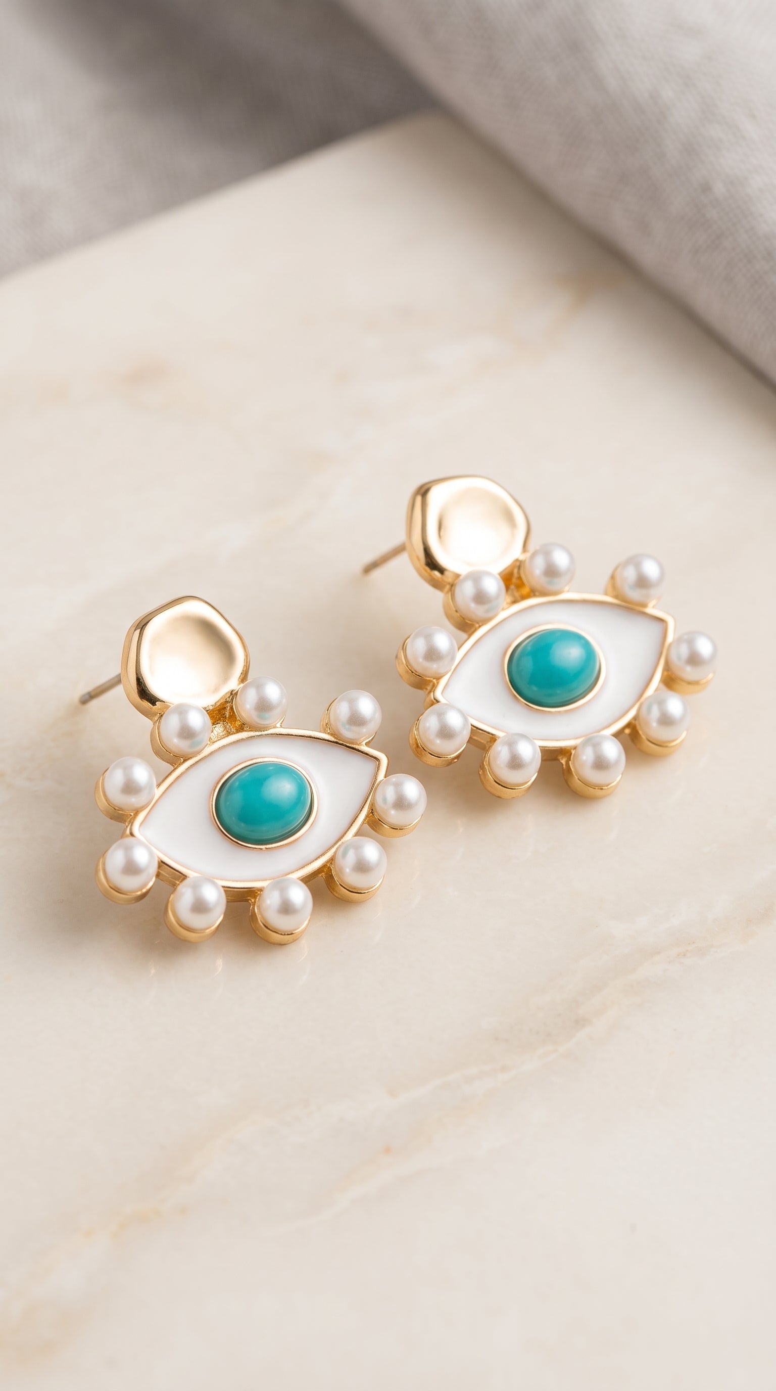 Brinco Olho Grego com Pérolas – Elegância, Proteção e Sofisticação